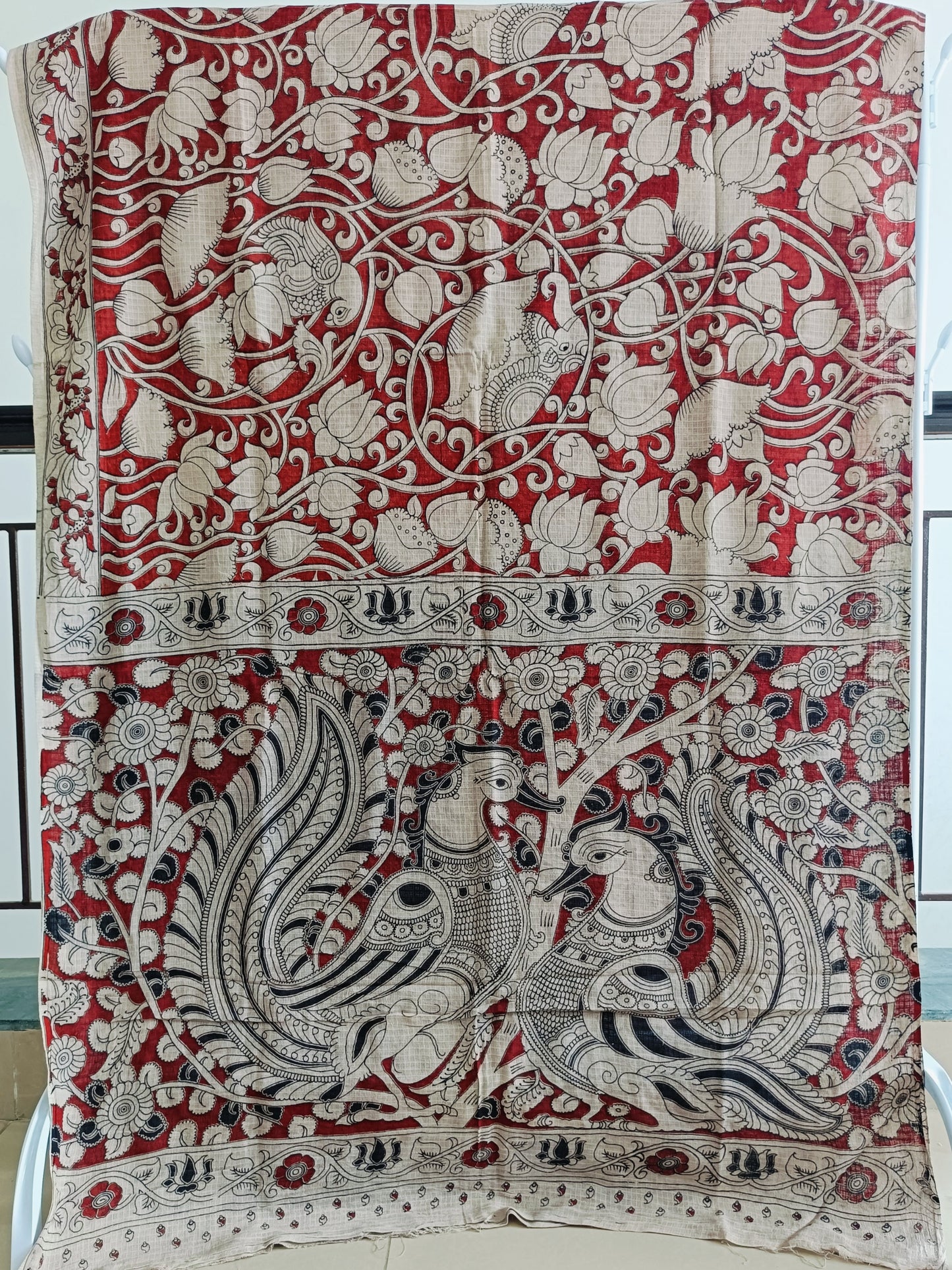 Decorative fabric with intricate patterns and peacock design on a red background