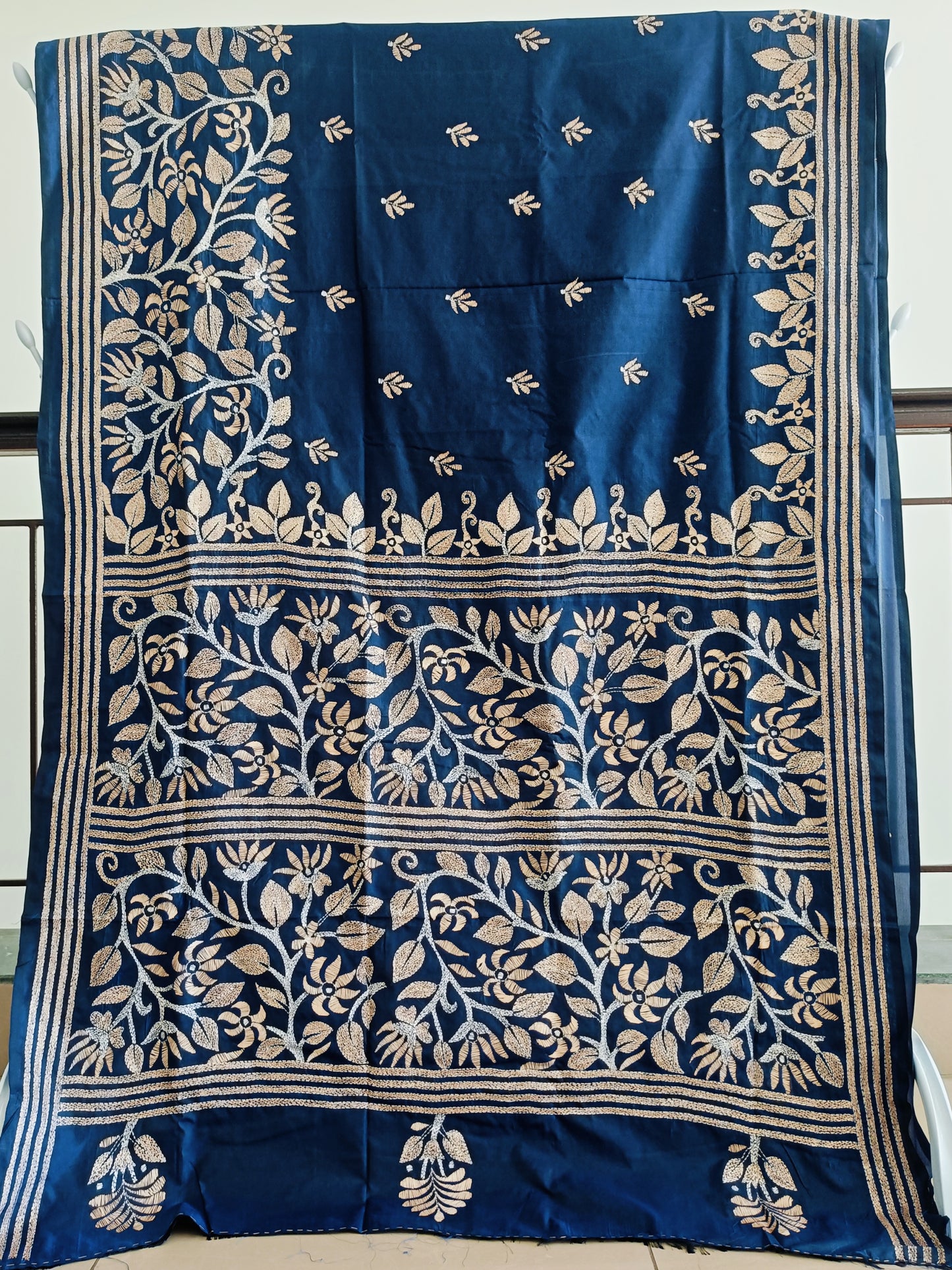 Blue saree with white floral patterns on a plain background