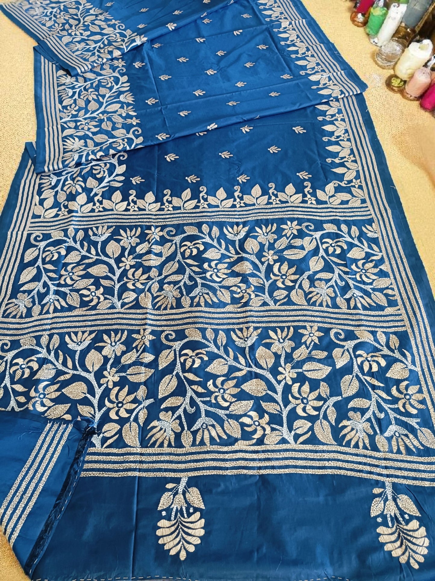 Blue saree with white floral patterns on a beige surface