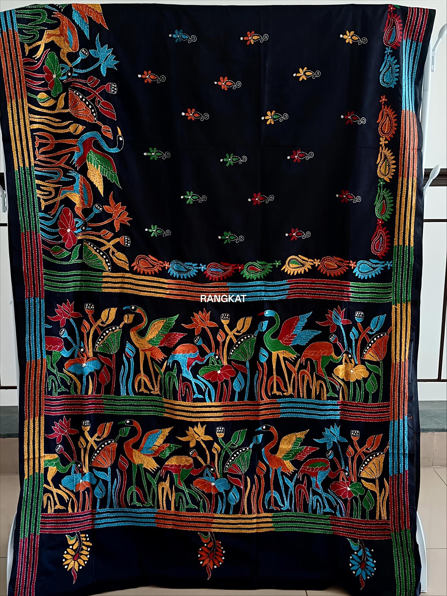Colorful embroidered textile with intricate patterns on a black background