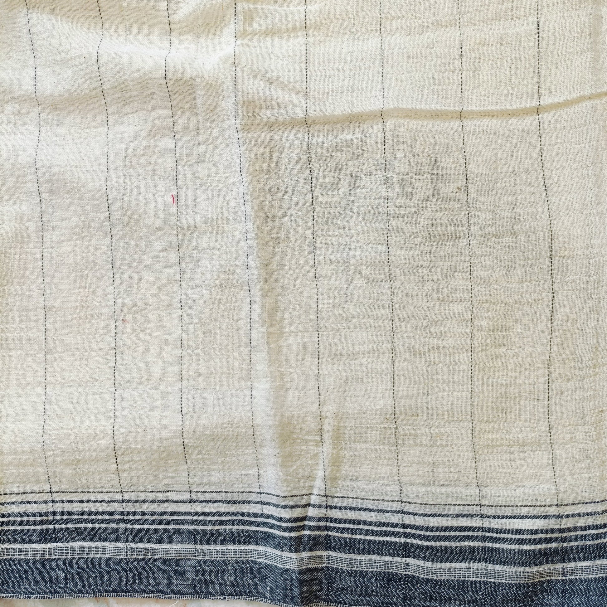 Close-up of a fabric with horizontal lines and blue stripes at the bottom