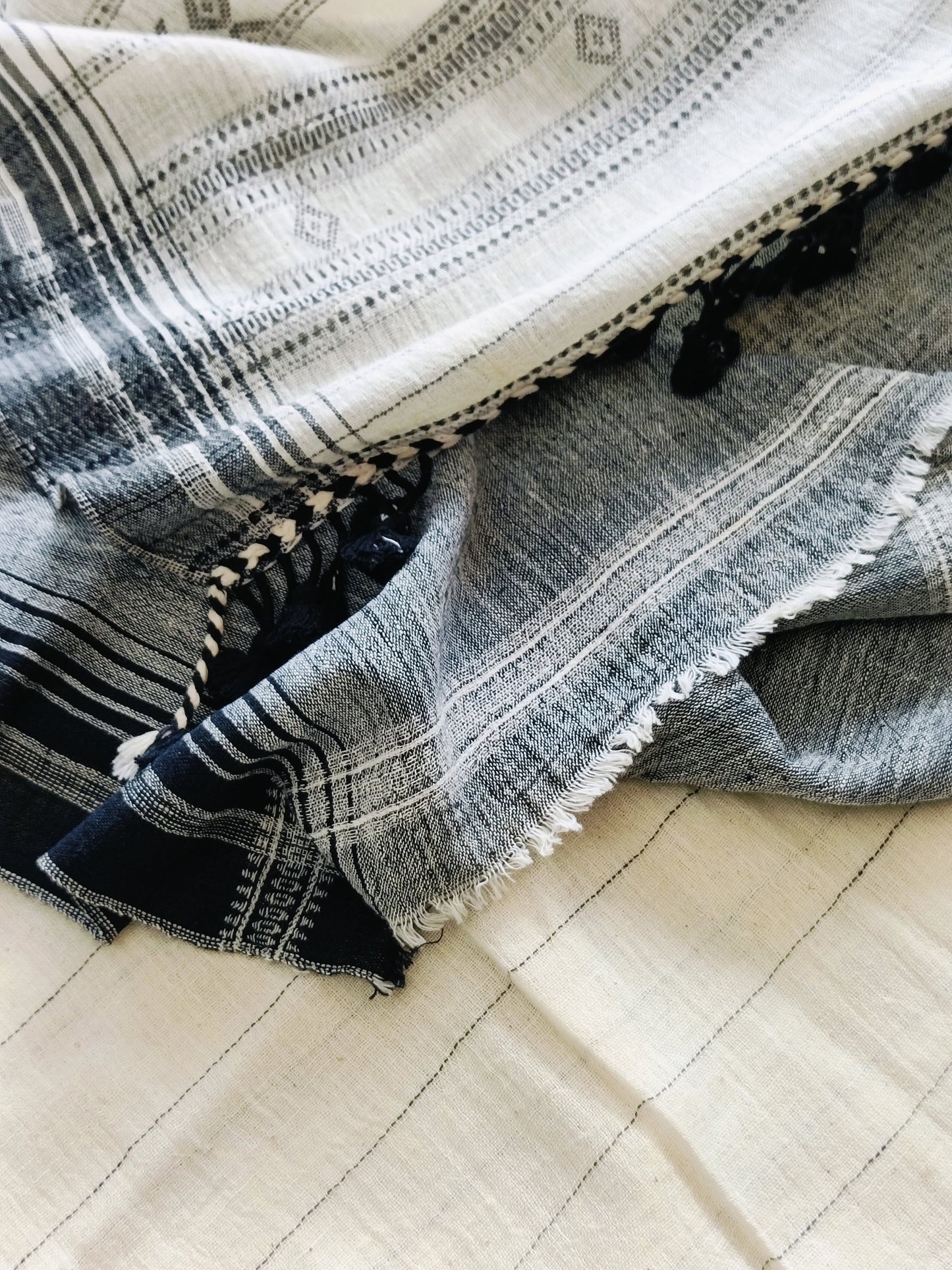 Stack of folded denim jeans on a checkered floor