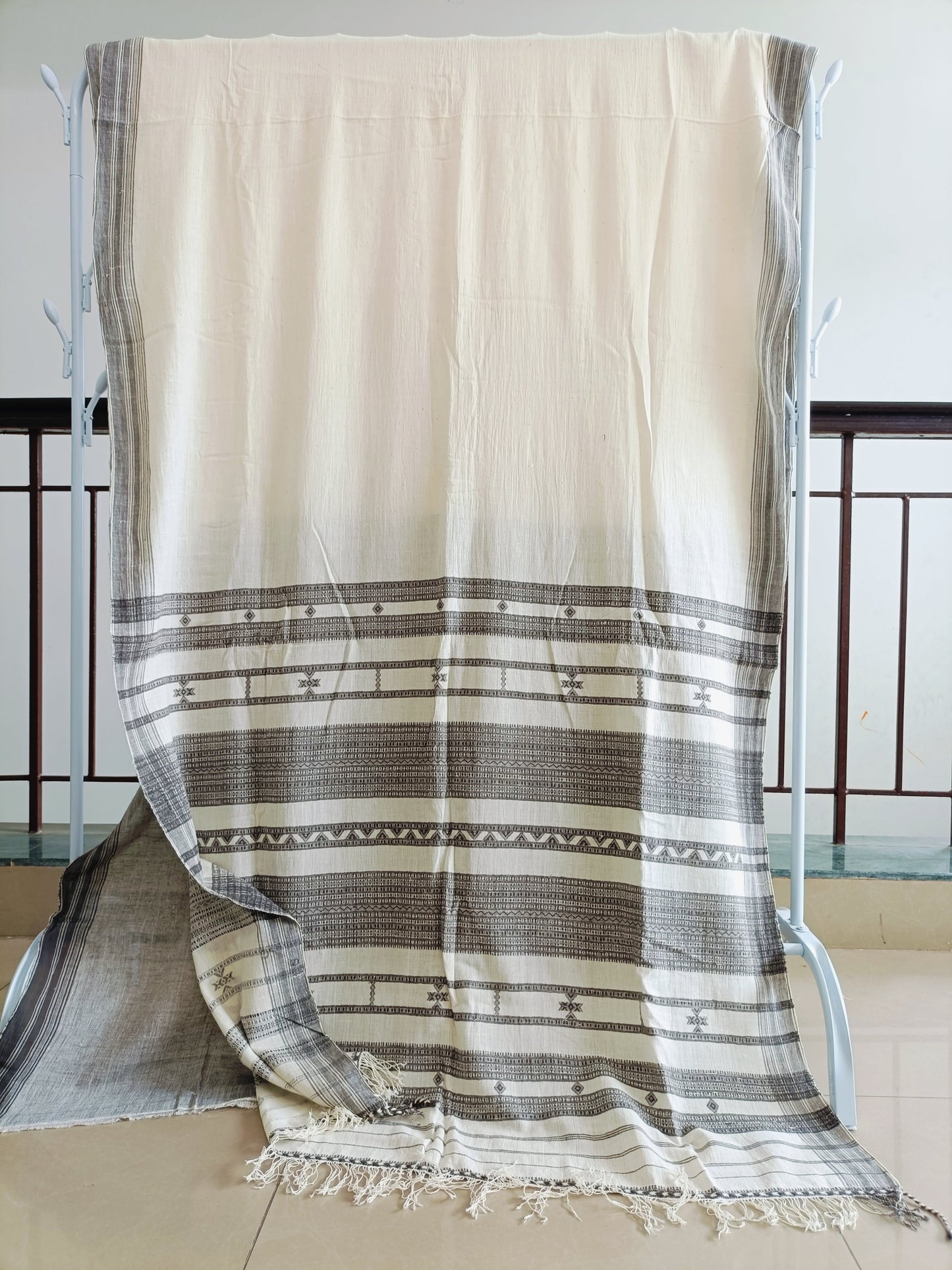Beige and brown striped towel draped over a chair with a white background