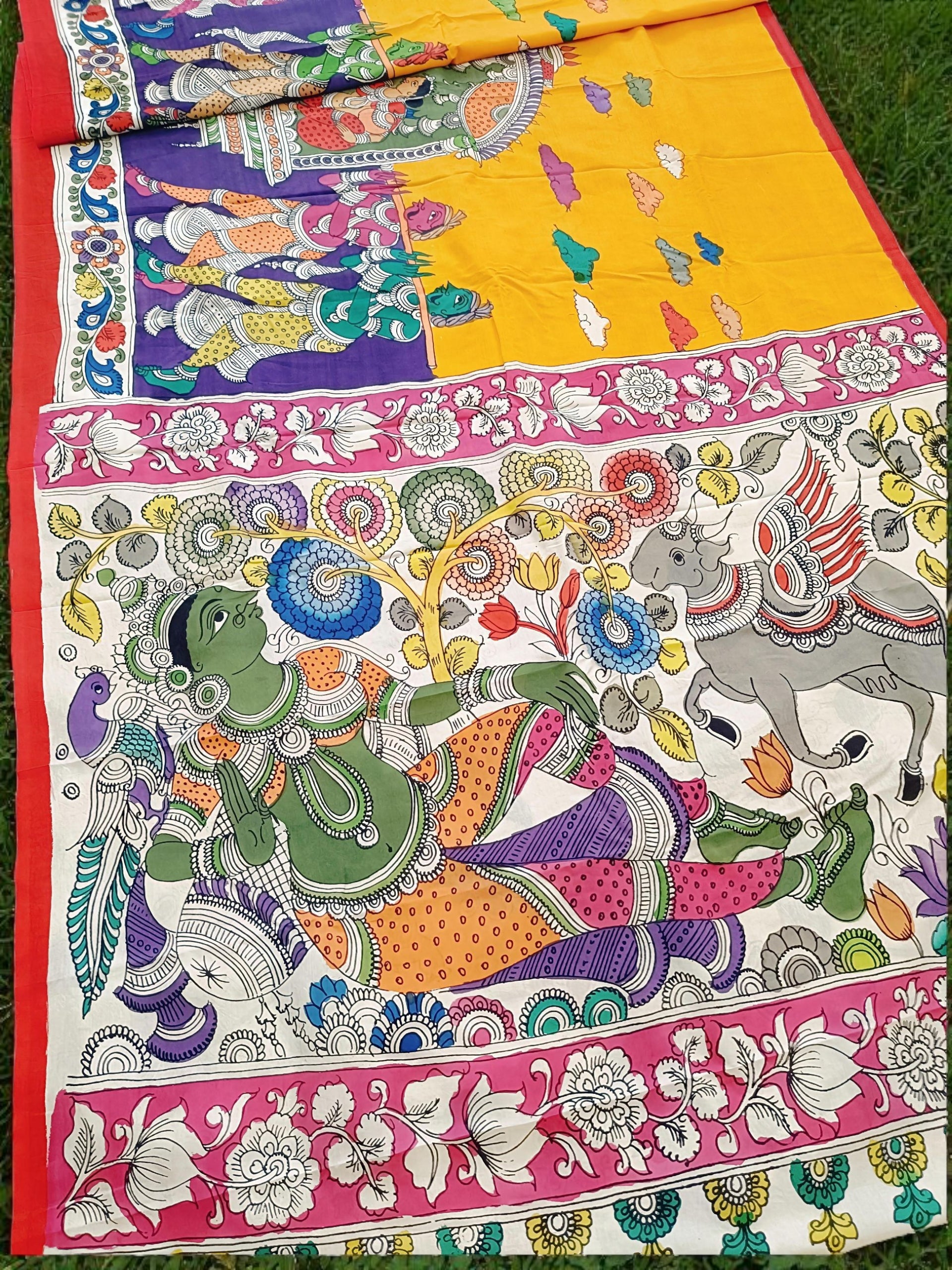 Colorful fabric with intricate designs and patterns, including a figure and floral elements.