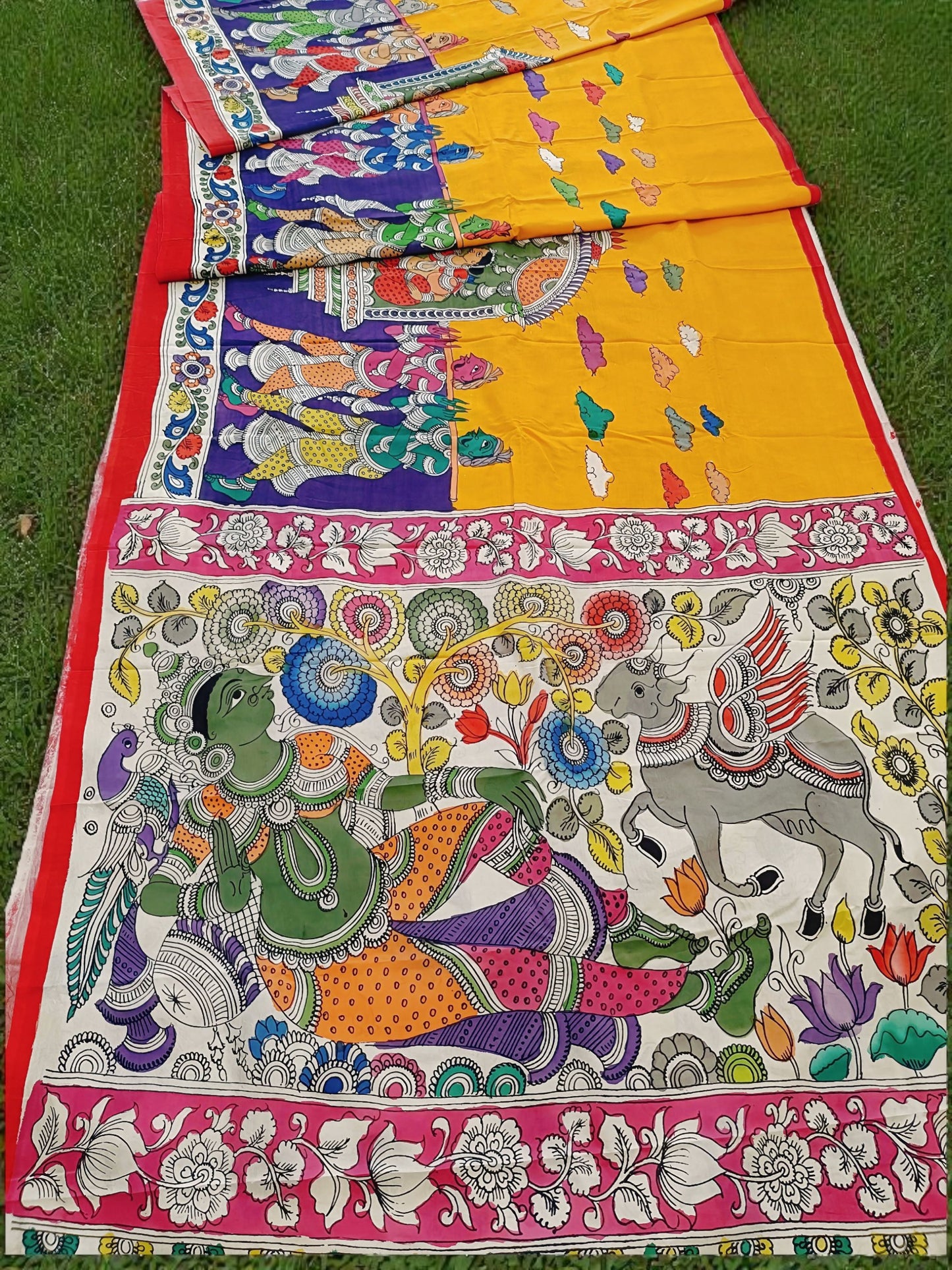 Colorful traditional fabric with intricate designs on a grassy background