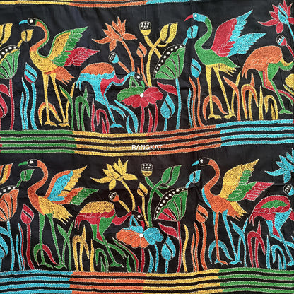 Colorful embroidered fabric with birds and floral patterns on a black background, featuring the brand 'Rangtak'.